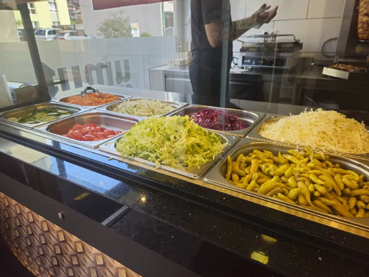 Salate, Tomaten, Gurken und Peperoni in der Zutatenvitrine